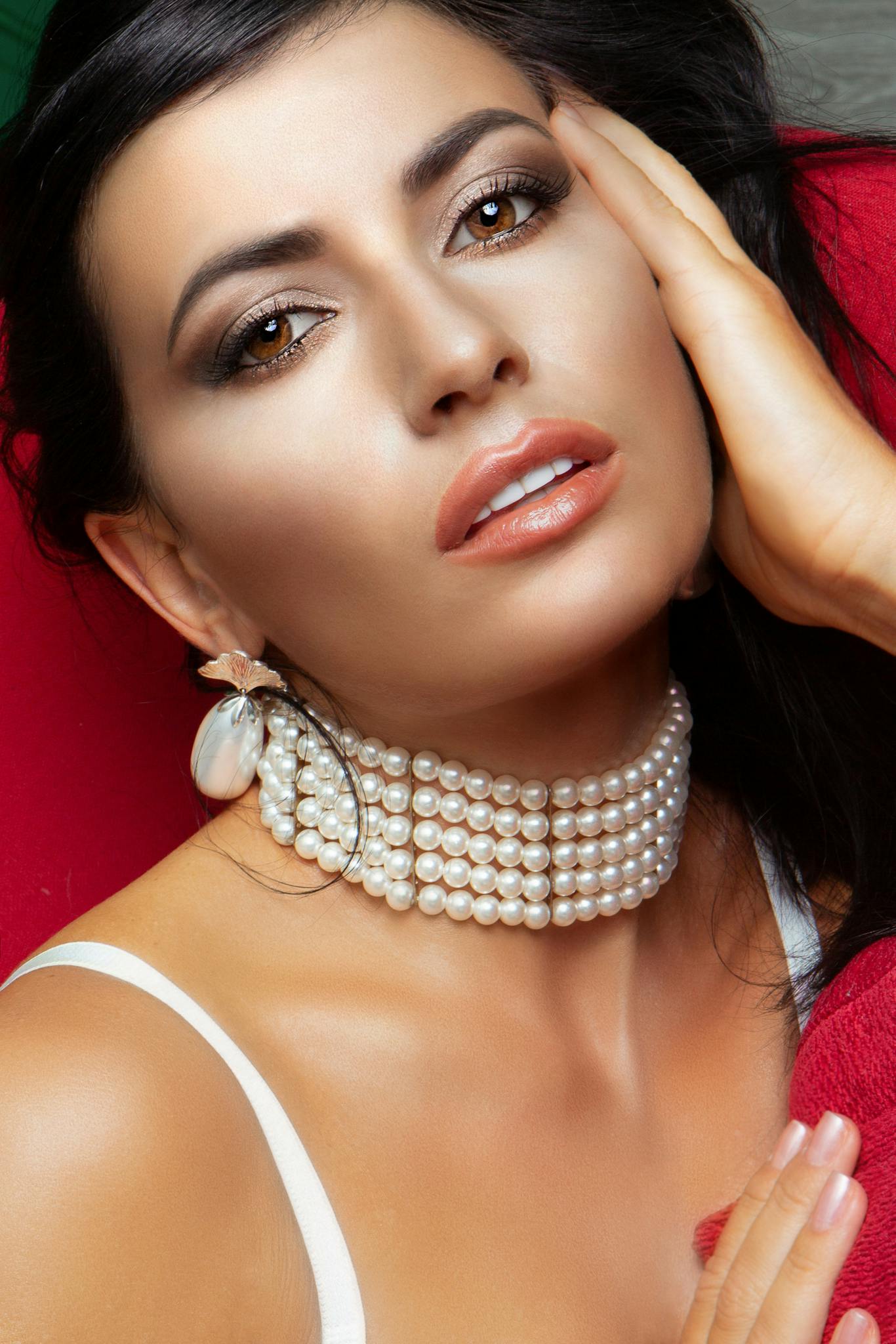 Gorgeous woman with necklace and earrings looking at camera